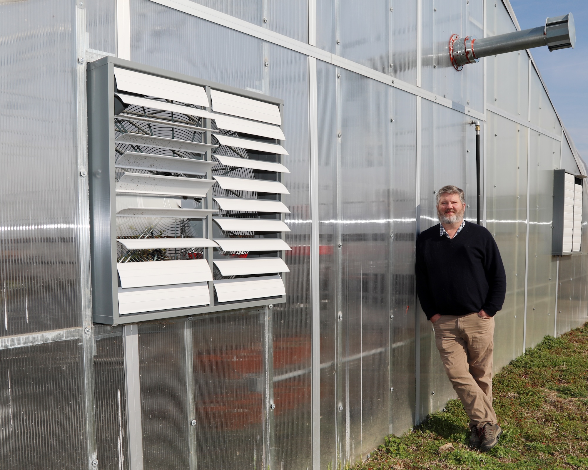 Jeff Beasley standing beside greenhouse