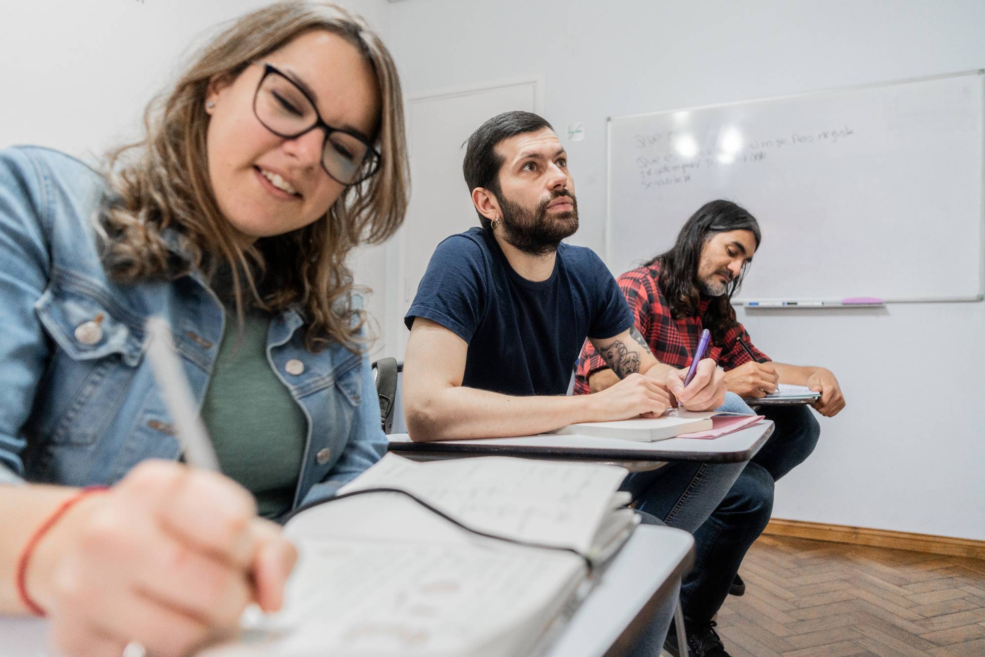 A professor supports a group of diverse college students as they study together at a table filled with books and notebooks, highlighting engaged learning and academic mentorship.