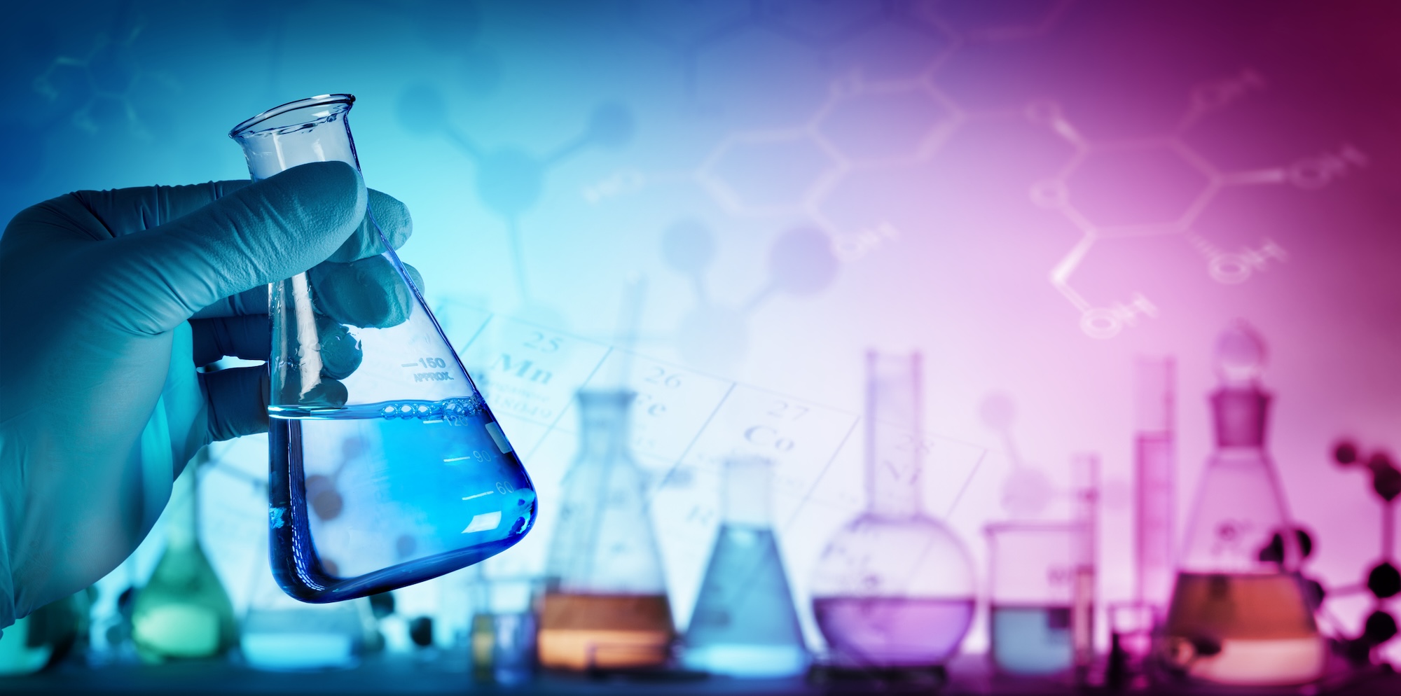 Gloved hand holding a beaker with others in the background