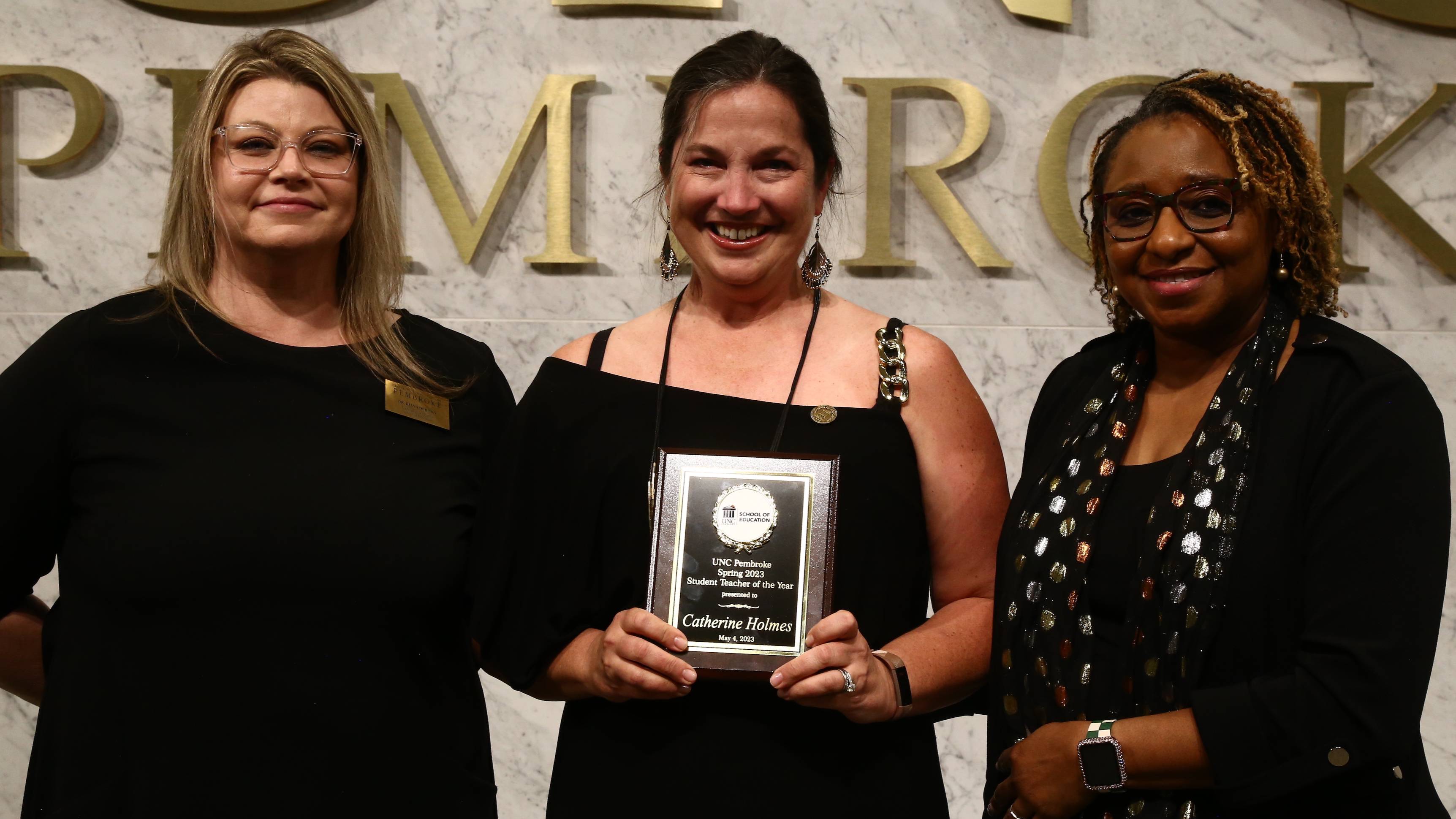 Dr. Diana Dubisky, left, and Dean Loury Floyd, right, presents Catherine Holmes with the 2023 Student Teacher of the Year Award