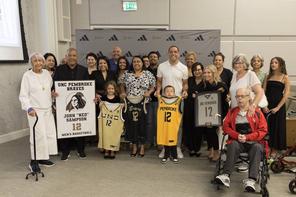 Ned Sampson's family displays his framed No. 12 jersey at the retirement ceremony.