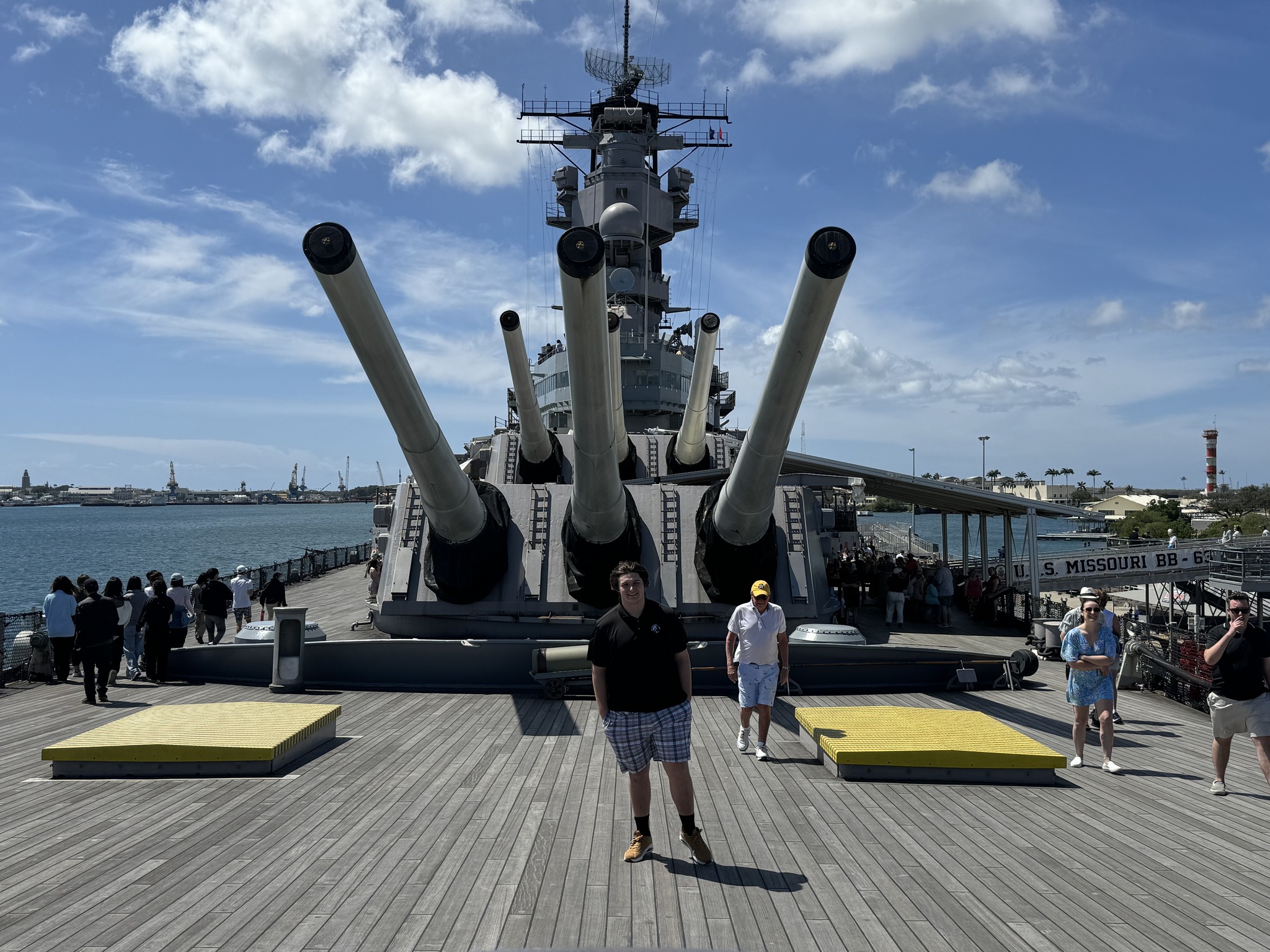 UNC Pembroke Research Fellow Mason Schweneker stands on the deck of a battleship in Pearl Harbor