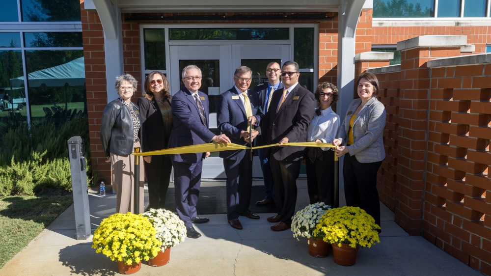 Members of UNCP administration stand in     front of the Brave Health Center for a ribbon cutting ceremony.