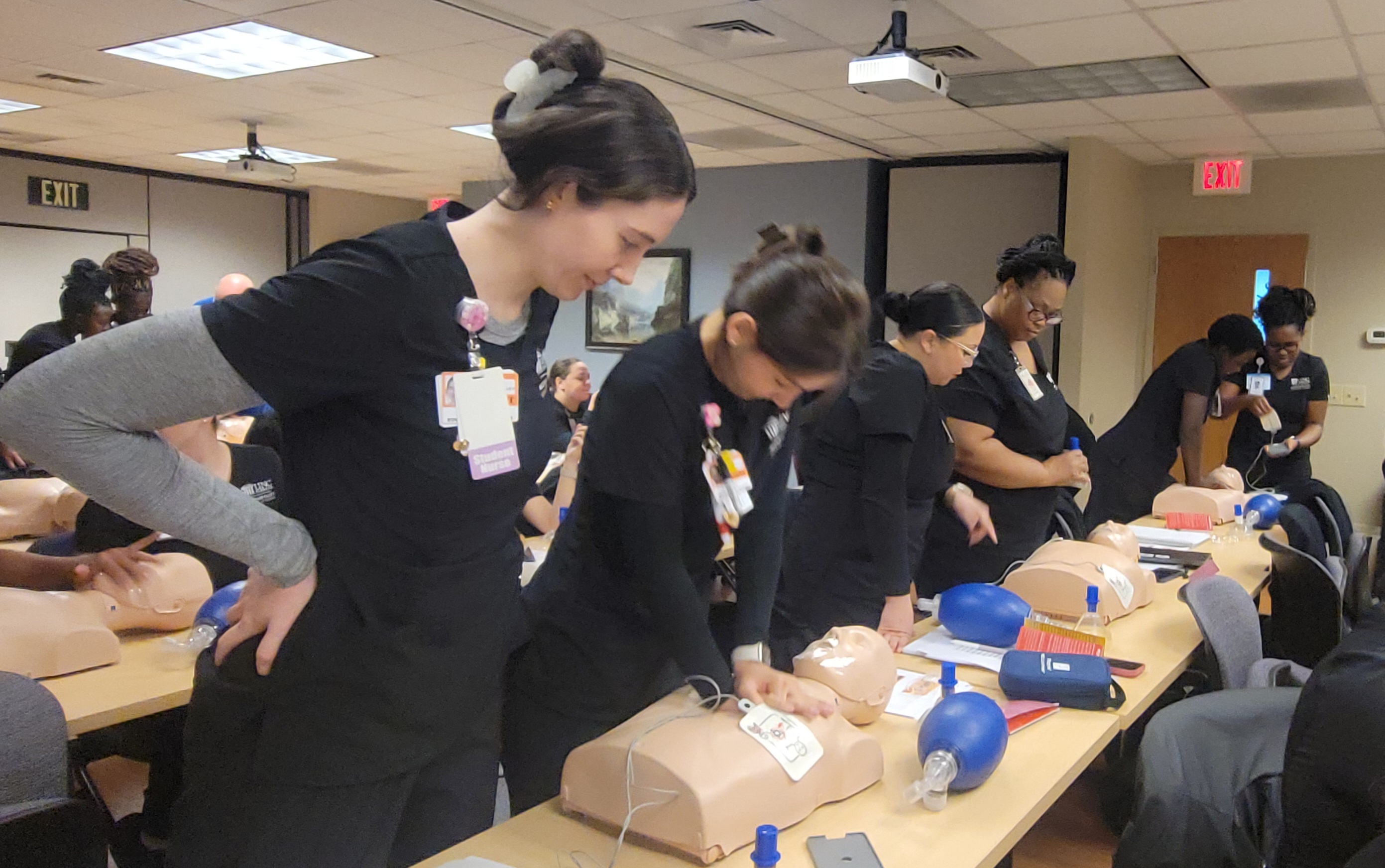 nursing students with a training mannequin