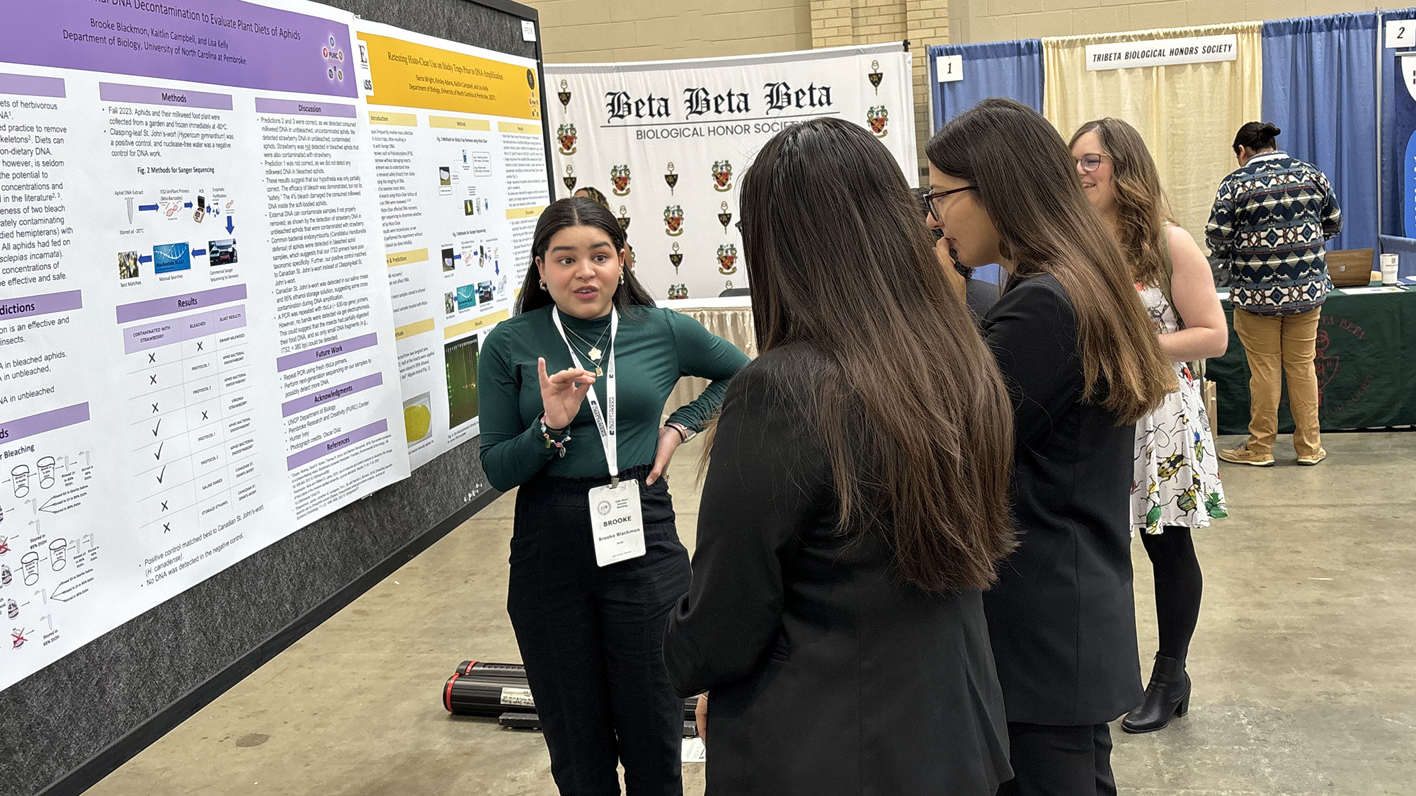 Brooke Blackmon speaking to ASB Conference attendees in front of her poster.