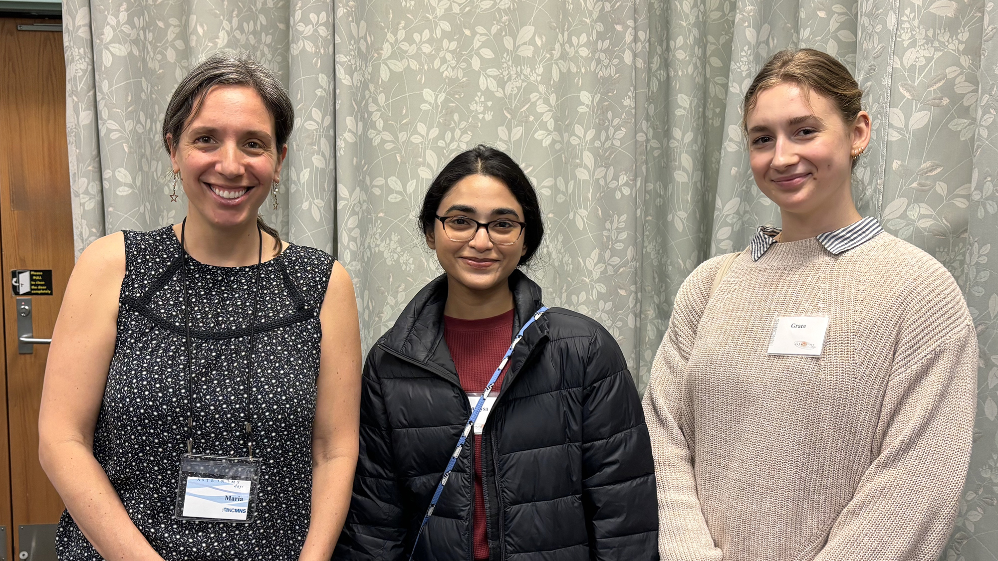 Three college students pose and smile at the event