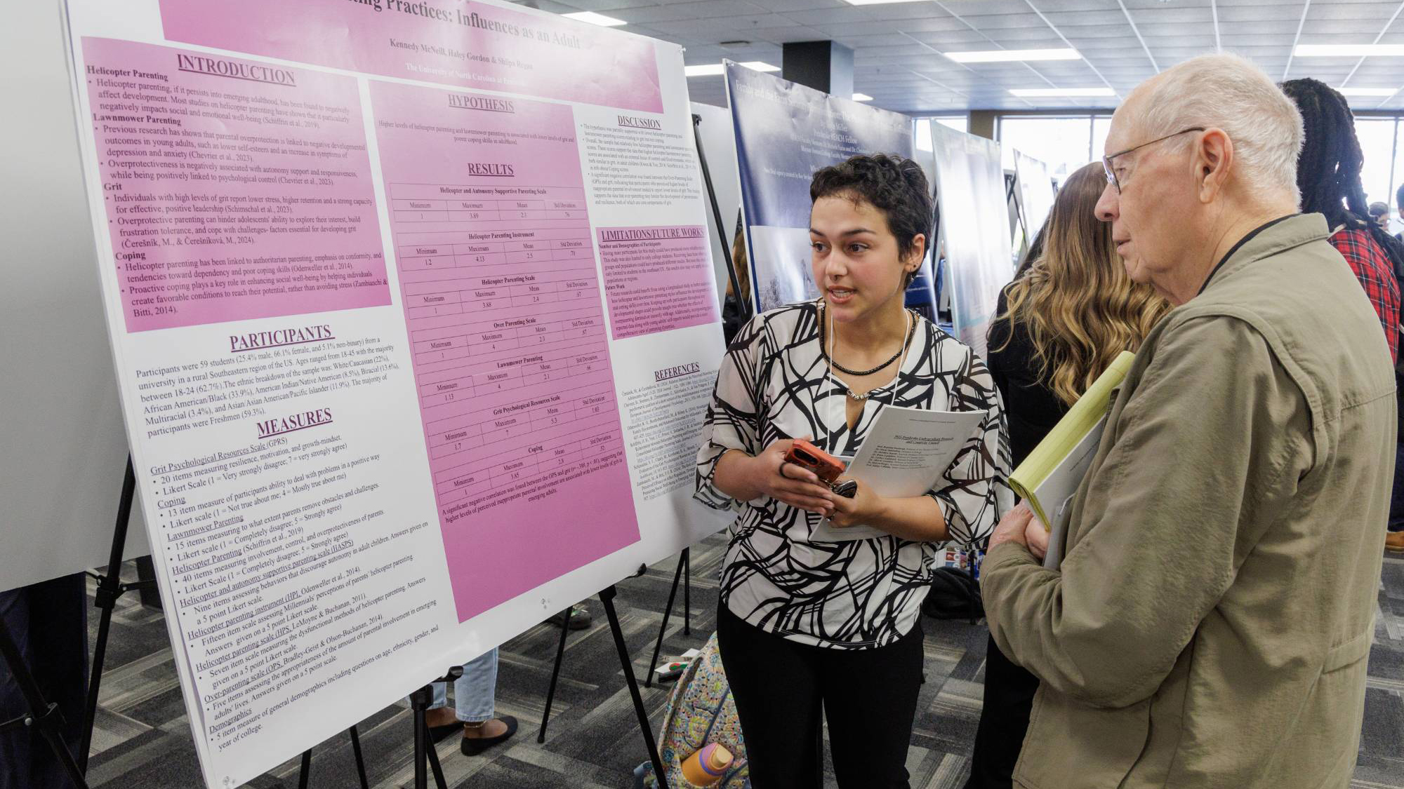 UNC Pembroke student presenting her research to a faculty member at a symposium poster session.