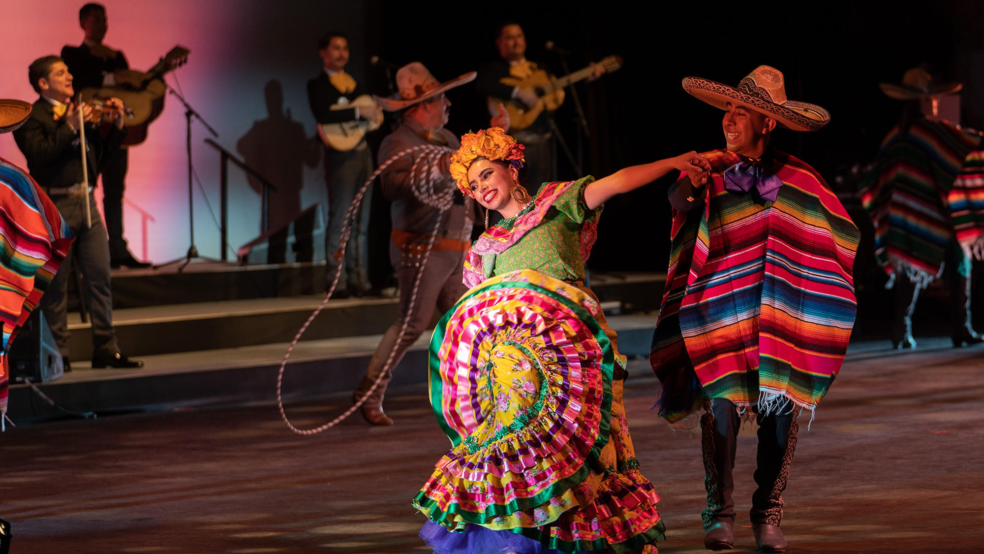 woman in brightly colored clothing dancing in the musical Ofrenda