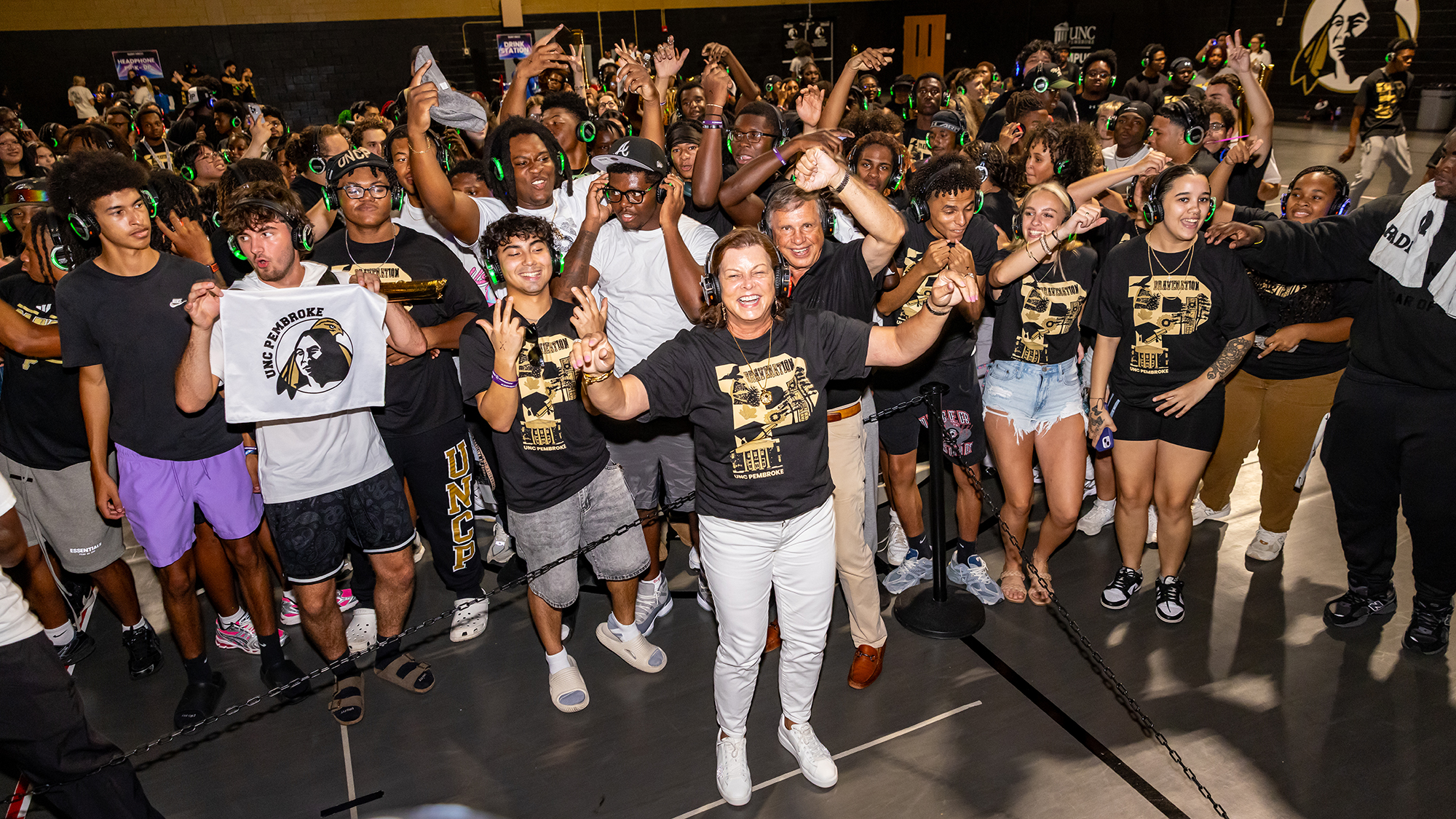 First Lady and Chancellor Cummings at a silent disco surrounded by students.