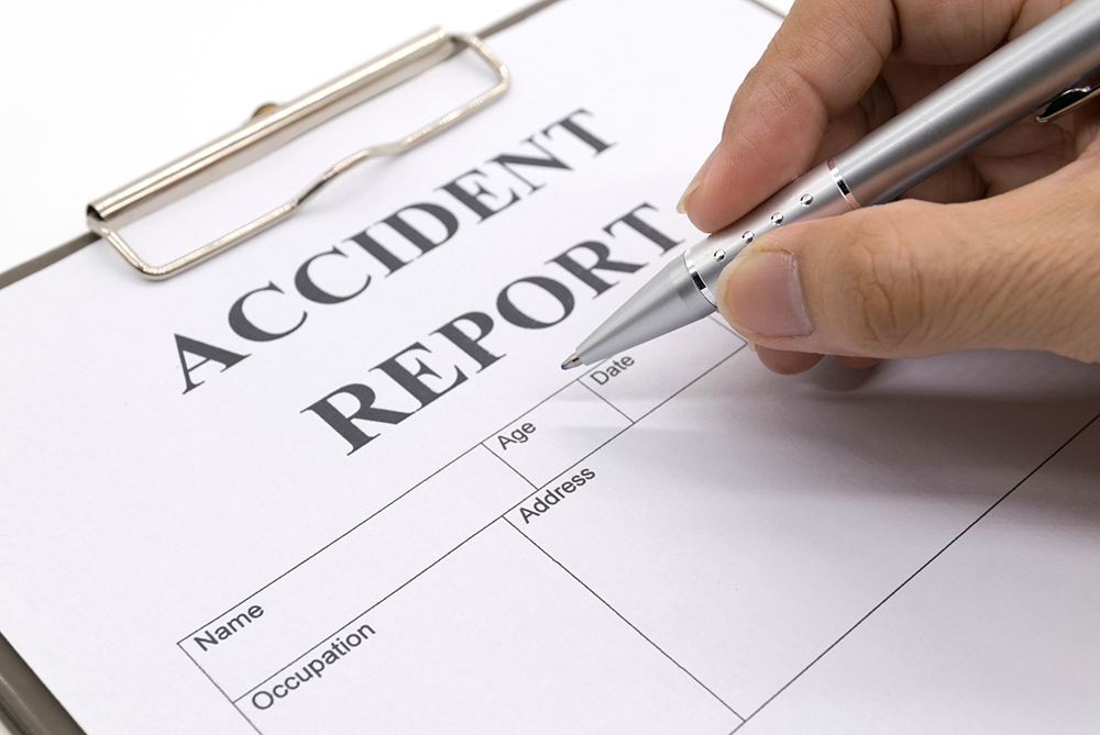 Accident Report on a clipboard with a pen