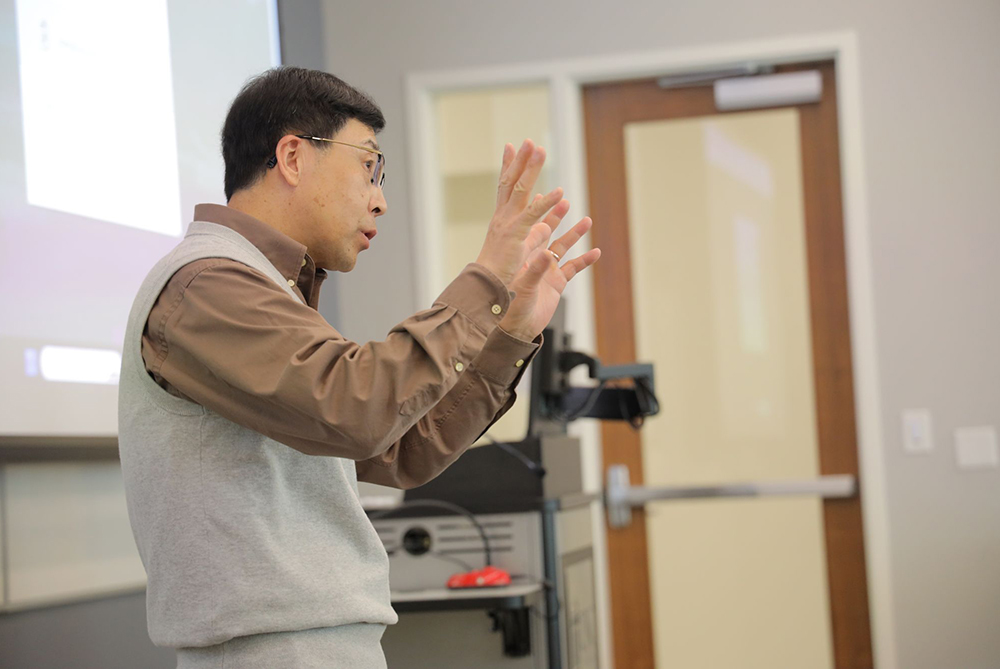 International professor gesturing during class.