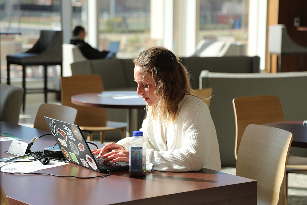 UNCP student in the business building on her computer
