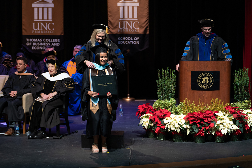 UNCP student being hooded at the graduate school commencement ceremony