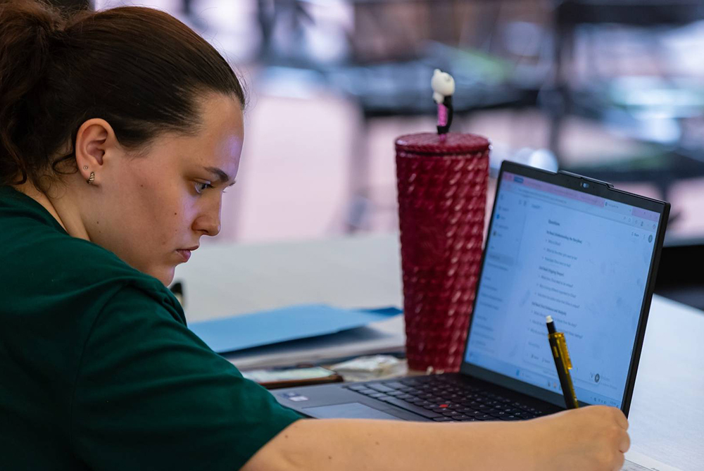 UNCP student looking at computer and notes
