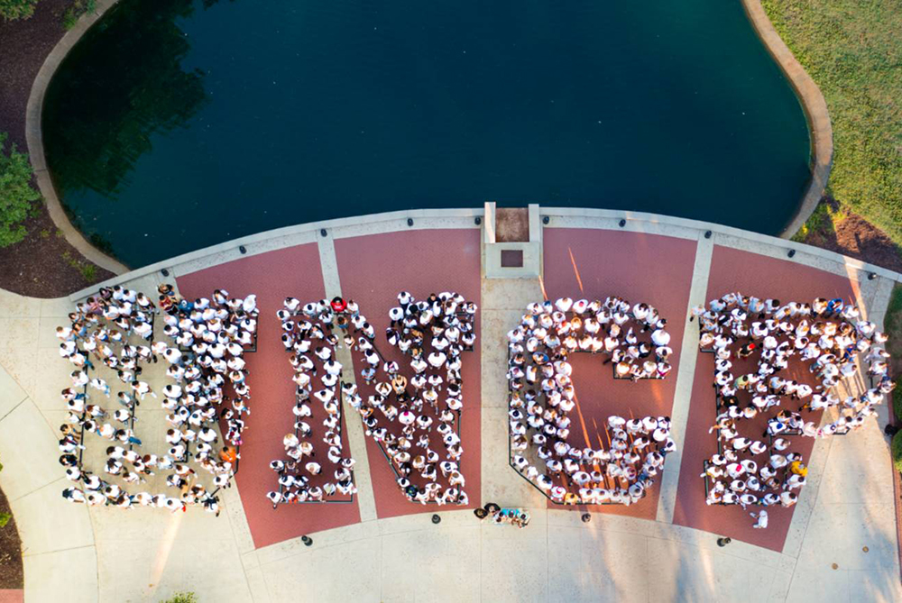 students forming letters "UNCP" for drone shot on campus