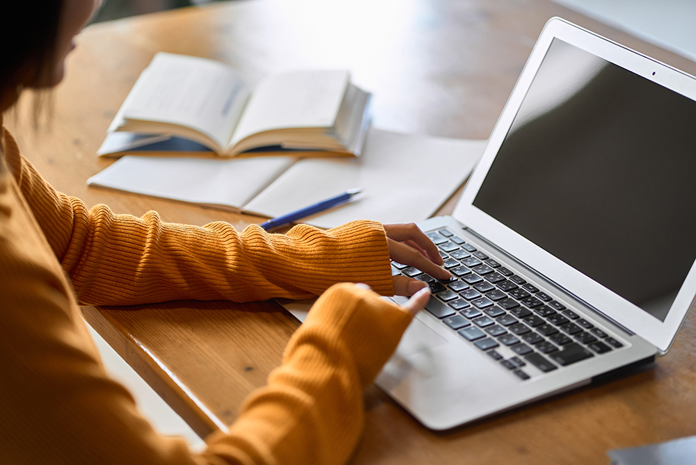 Student applying for accessibility services on laptop at a table.