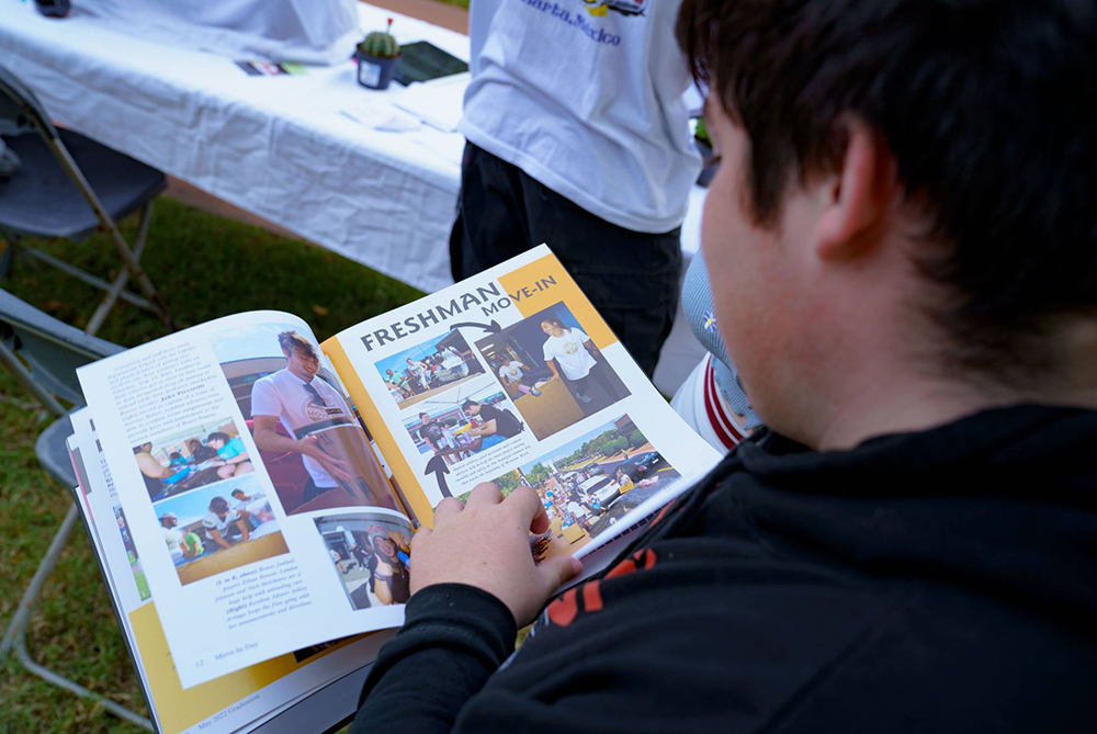 A UNCP student flipping through the pages of the yearbook