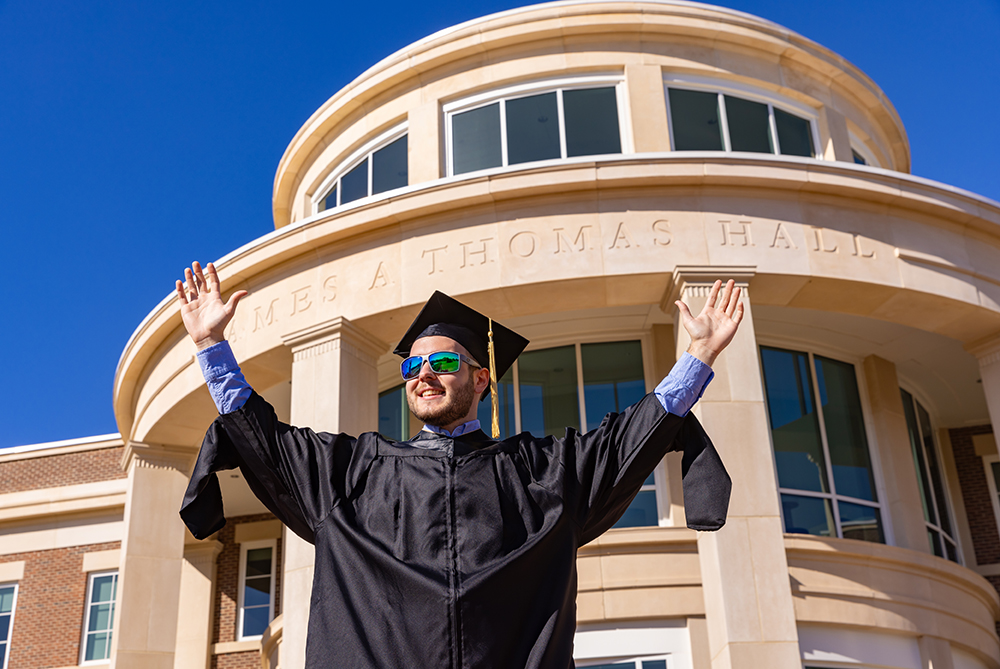 student in front of Thomas Hall at UNCP
