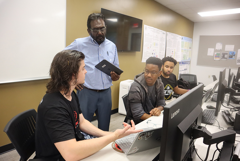 Cybersecurity teacher and students in a computer lab at UNC Pembroke