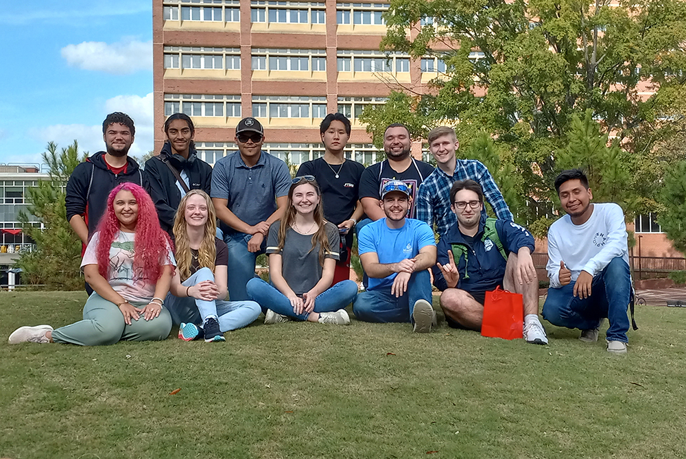 group of UNCP students sitting on the campus lawn