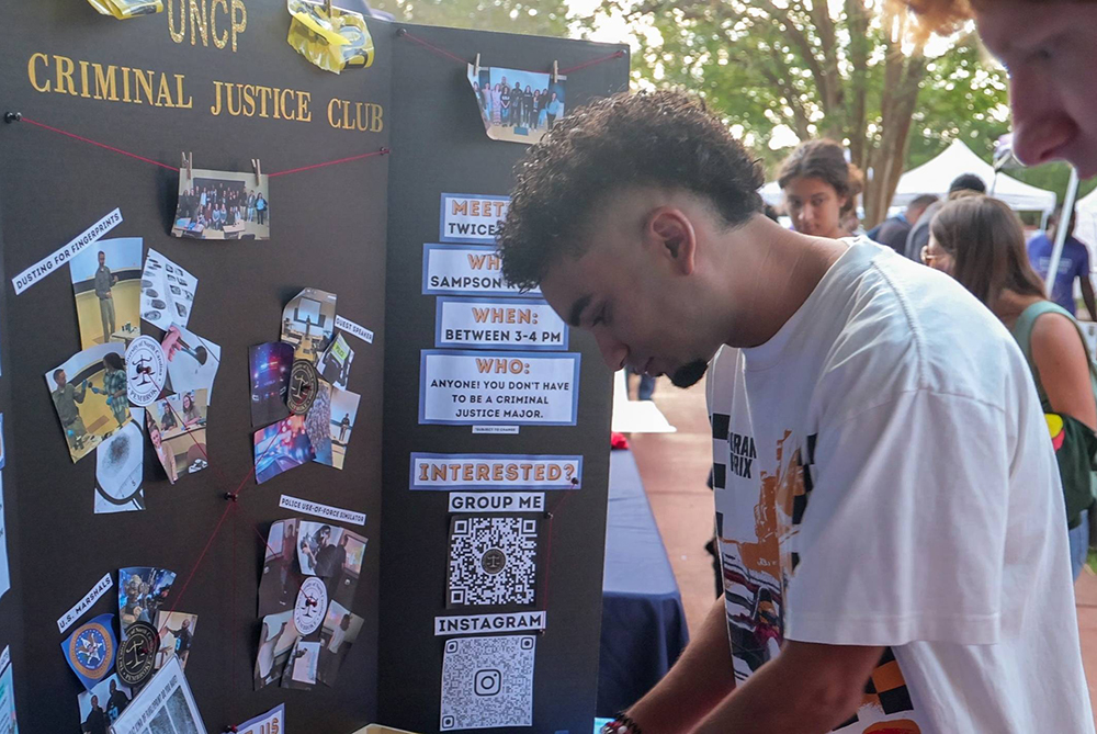 Students check out the Criminal Justice Club table at a campus event.
