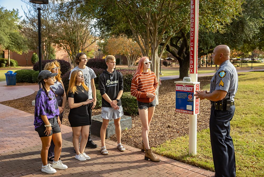 Campus Police demonstrating how to use emergency call box