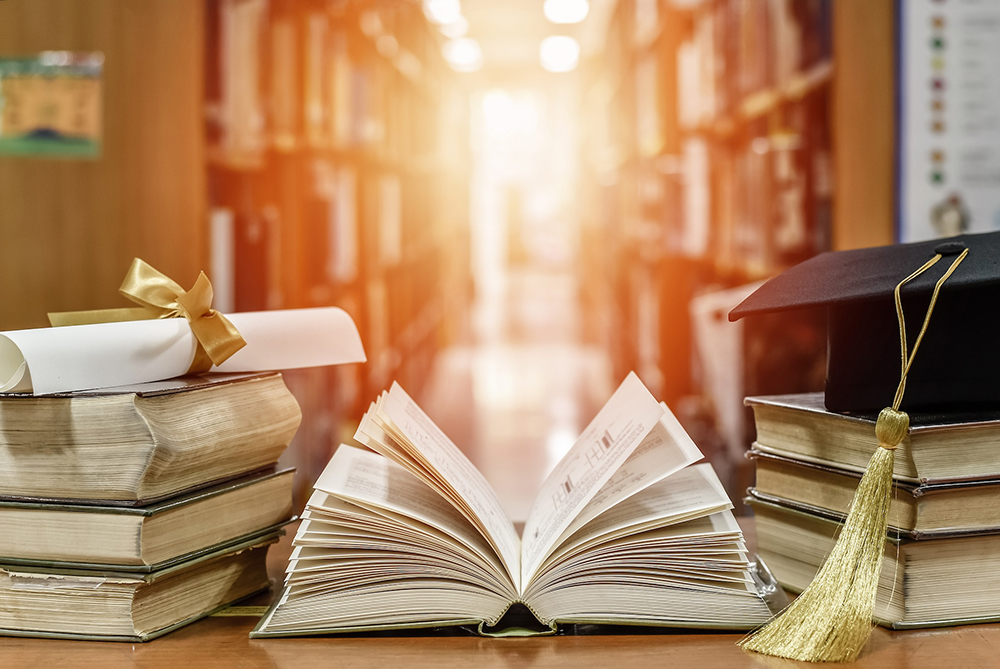 library with books and graduation cap and diploma
