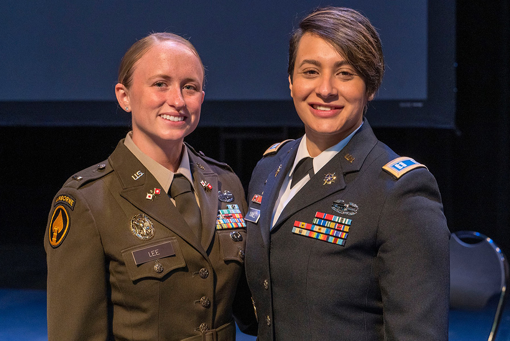 two UNCP graduates in military uniforms