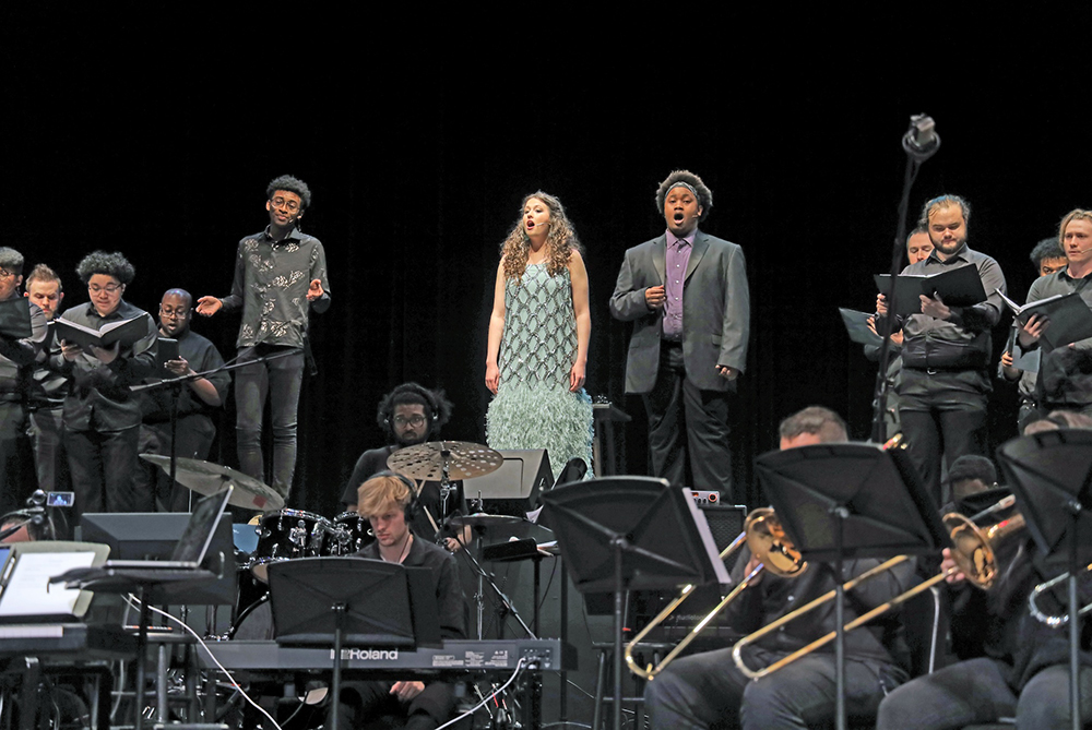 students on stage at UNCP performing with instruments and singing