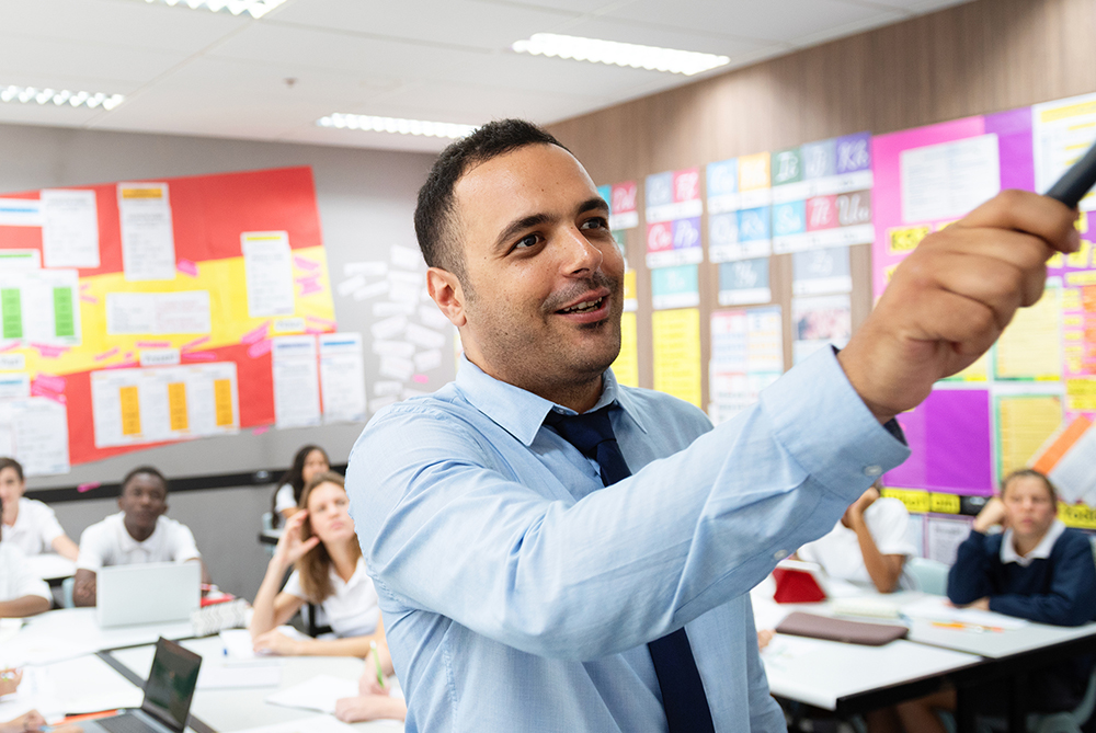 American Indian male teacher in front of classroom