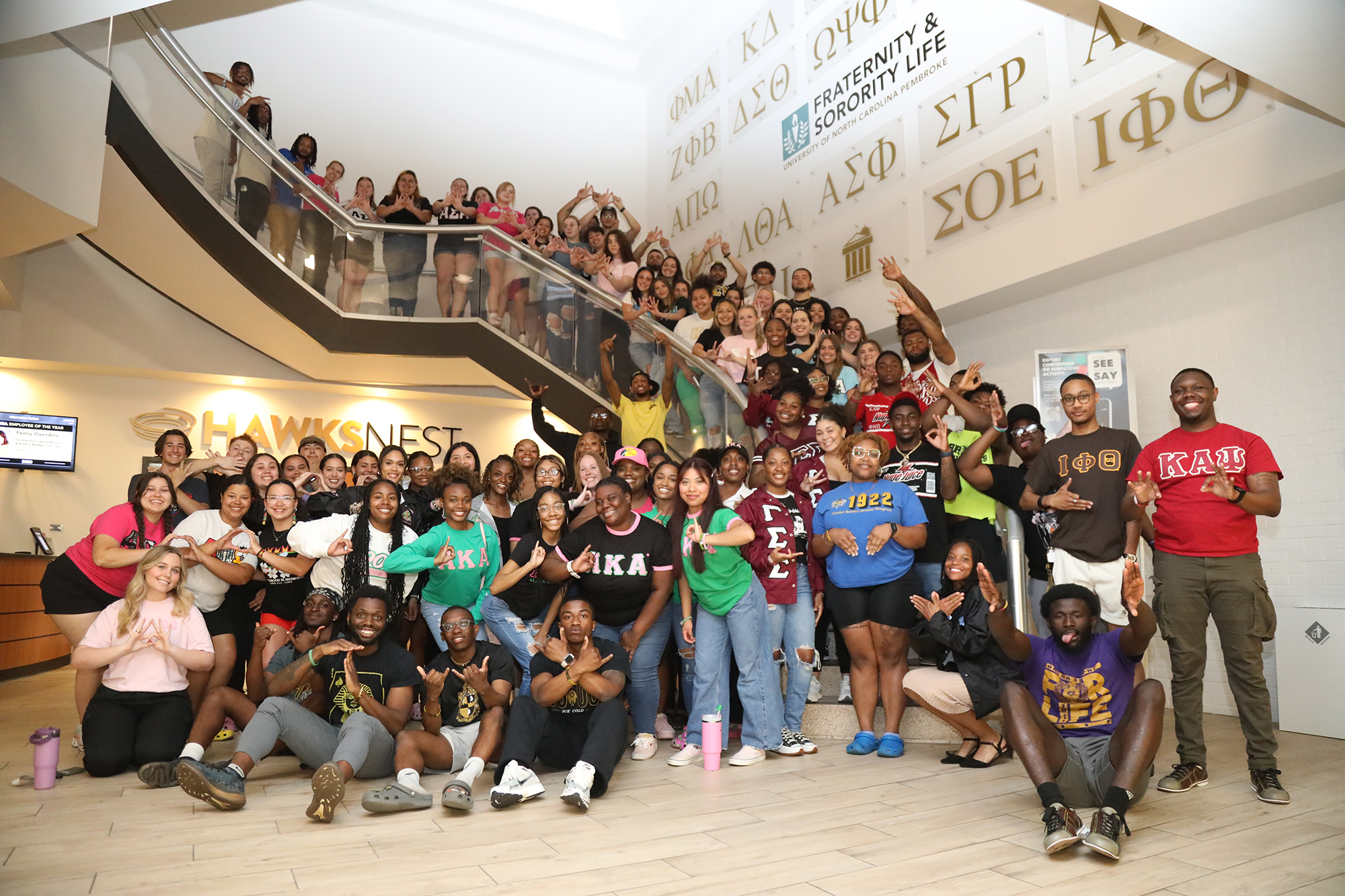 UNCP students representing a variety of sororities and fraternities on the staircase on campus in the Student Center.