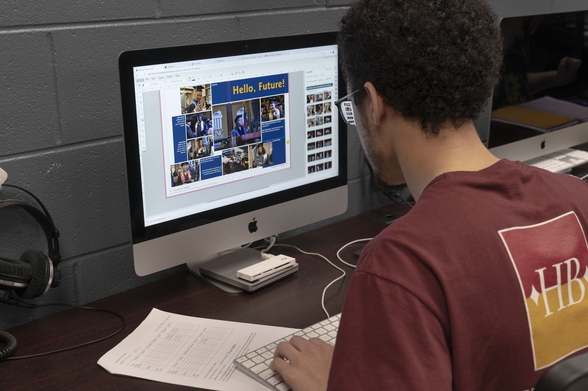 Student on computer designing yearbook spread at UNCP