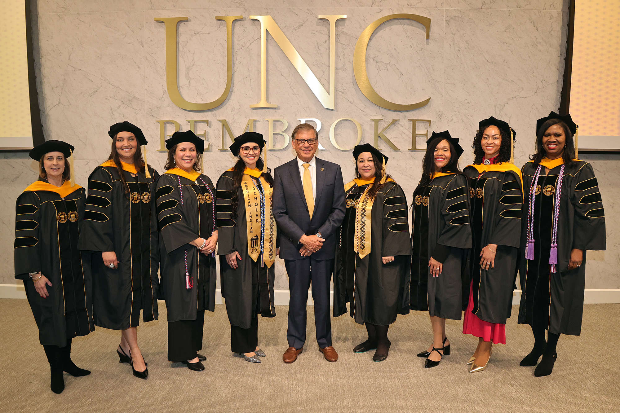 The first graduating class of the UNCP DNP program dressed in regalia and pitured with Chancellor Robin Gary Cummings.