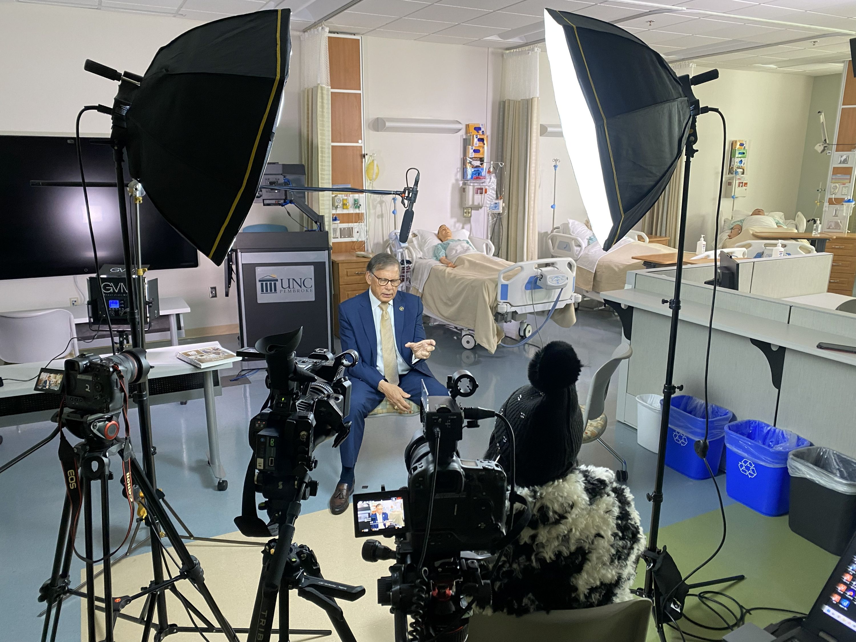 Behind the scenes view of the lighting and camera setup for Chancellor Robin Cummings interview in the nursing simulation lab.