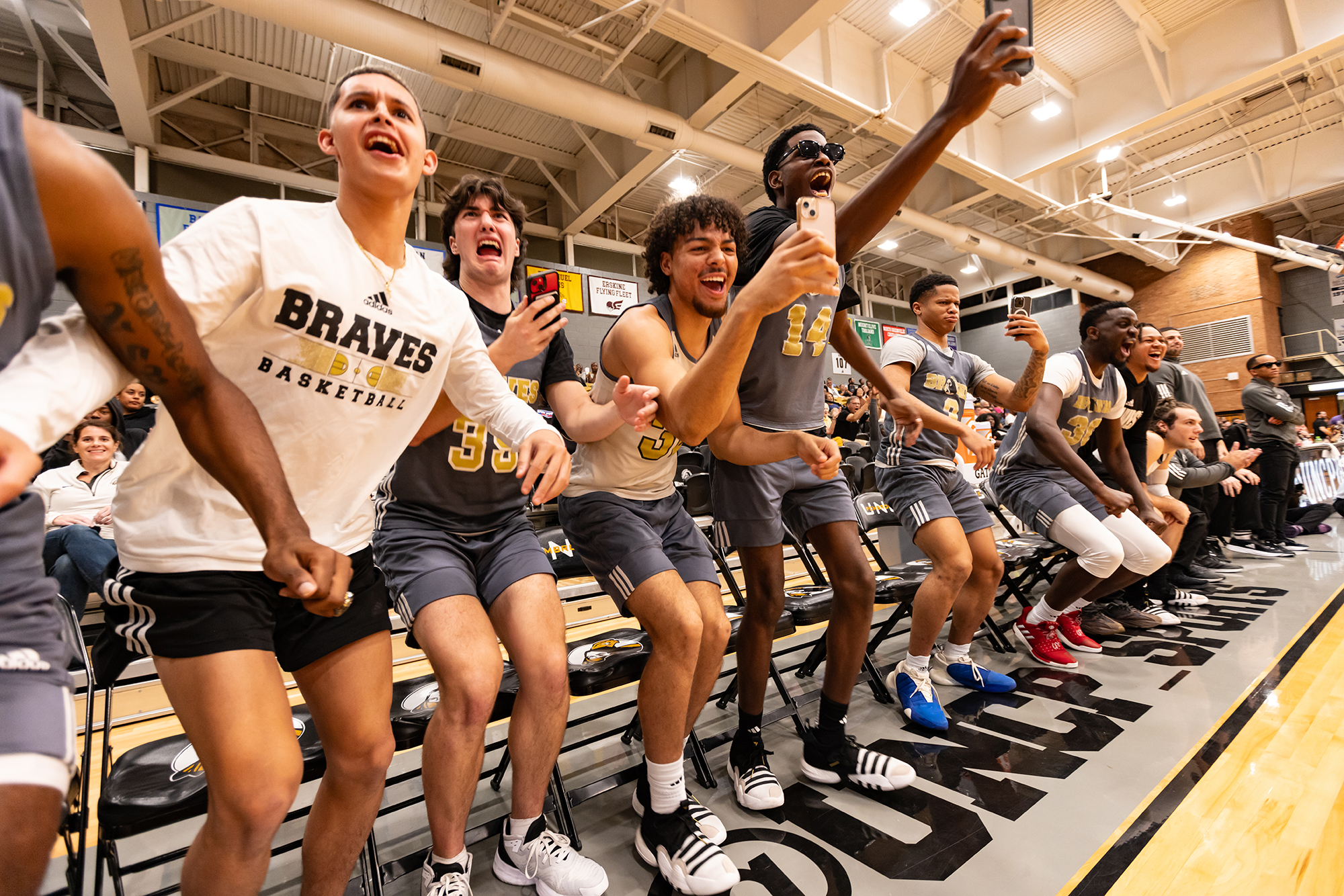 UNCP men's basketball team cheering from the sidelines